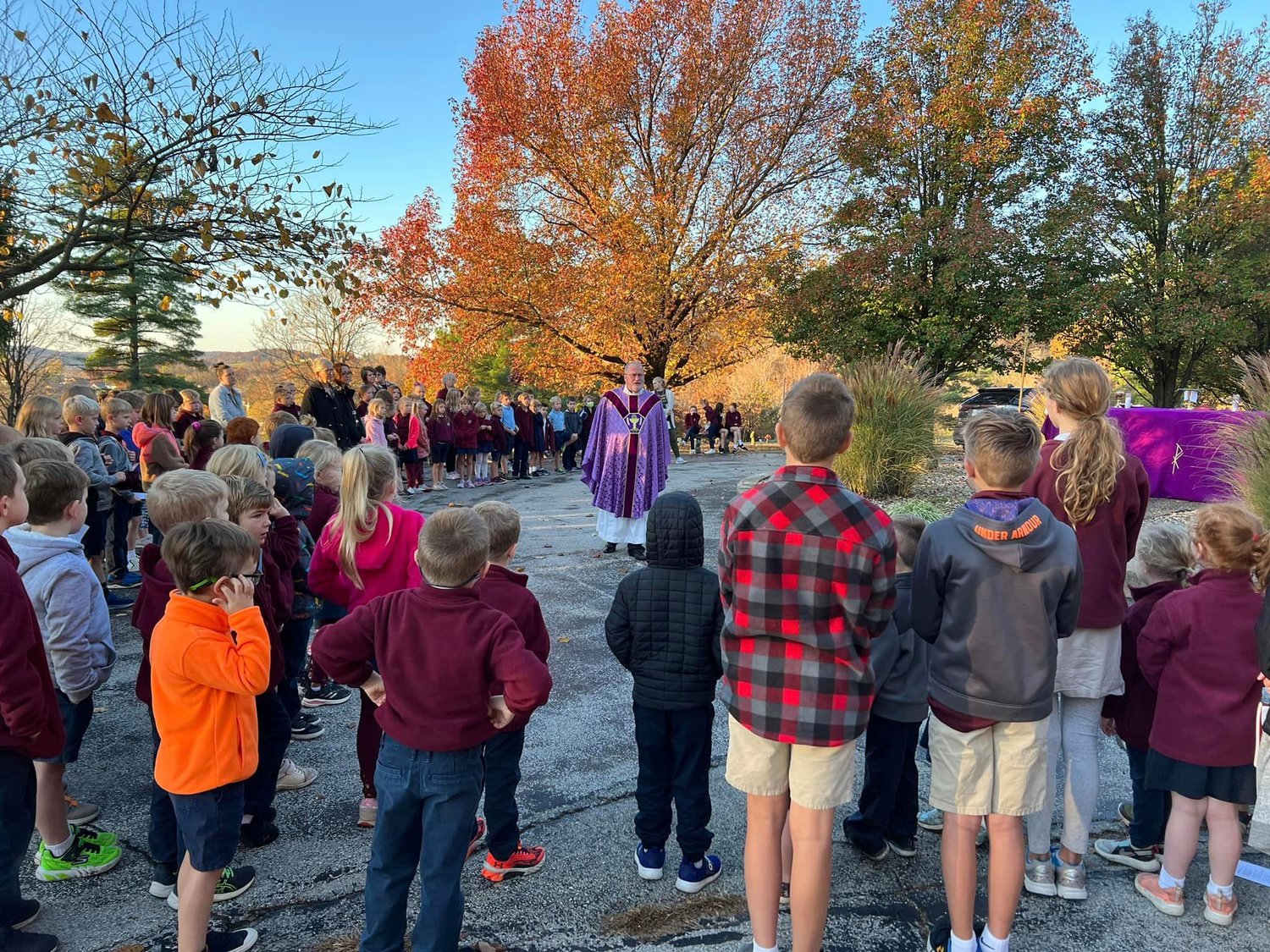 Students of St. George School in Hermann join Father Philip Niekamp, pastor of St. George Parish in Hermann and Church of the Risen Savior Parish in Rhineland, for Mass in St. George Cemetery in Hermann for All Souls Day.